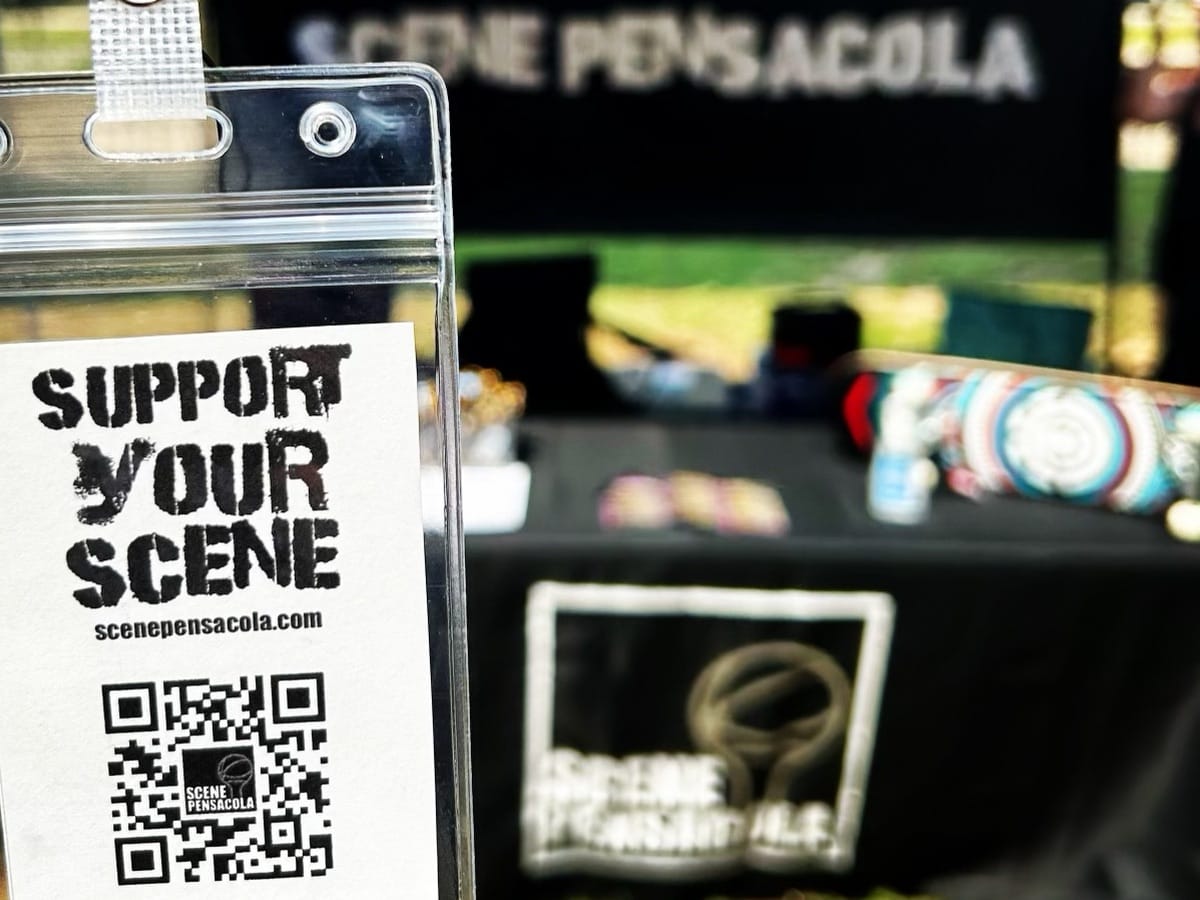 Scene Pensacola booth with Support Your Scene lanyard in foreground.