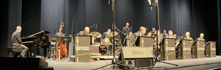 A panoramic image of the U.S. Navy Band Commodores playing onstage at the Saenger Theatre in Pensacola