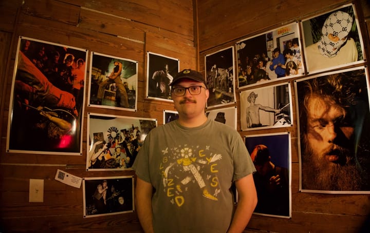Andrew Velasco in front of photographs from the Punkdemic exhibition at 309 Punk Project.